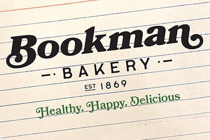 Investor report cover featuring recipie cards on top of a dark brown background highlighting the title of the report, Bookman Bakery Investor Report